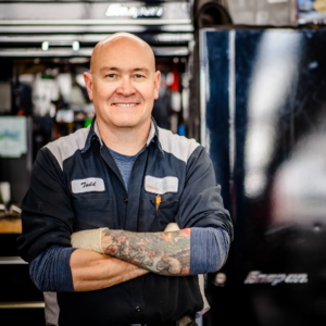 smiling auto expert with crossed arms
