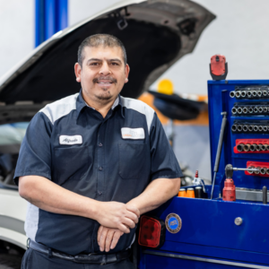 smiling technician in front of vehicle